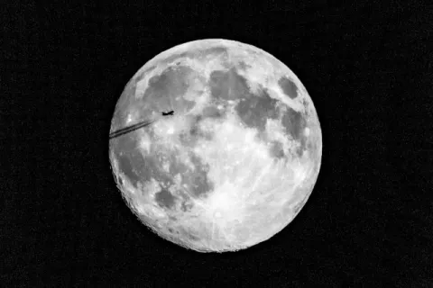 Flugzeug vor Supermond