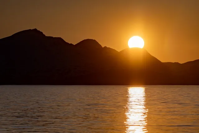 Die Mitternachtssonne über der Insel Reinøya im Ullsfjord in Norwegen