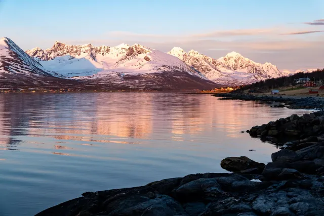 Die Spiegelung der Lyngenalpen in der Sør-Lenangen Bucht und das nun golden schimmernde Dorf Lenangsøyra.