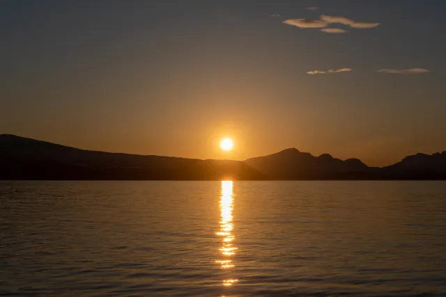 The midnight sun over the island of Reinøya in the Ullsfjord in Norway