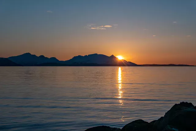 Die Mitternachtssonne über der Insel Reinøya im Ullsfjord in Norwegen